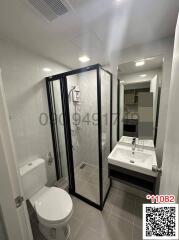 Modern bathroom with a shower enclosure, toilet, sink, and mirror