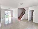 Spacious living room with natural lighting and staircase