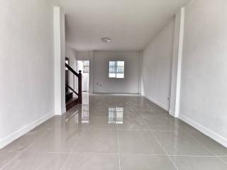 Empty spacious interior of a modern building with glossy tiled flooring and staircase