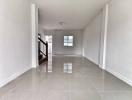 Empty spacious interior of a modern building with glossy tiled flooring and staircase