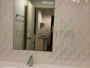 Clean modern bathroom with a sink and mirror reflecting the interior