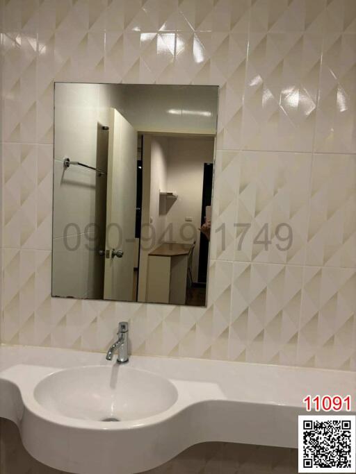 Clean modern bathroom with a sink and mirror reflecting the interior