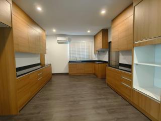 Spacious modern kitchen with wooden cabinets and stainless steel appliances