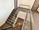 Modern interior staircase with glass railing and wooden steps