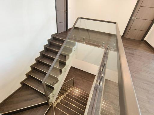 Modern interior staircase with glass railing and wooden steps
