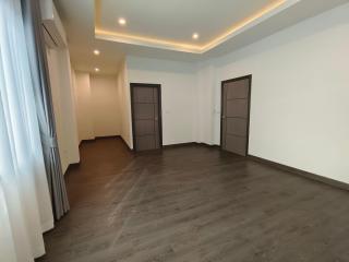 Empty bedroom with hardwood flooring and recessed lighting