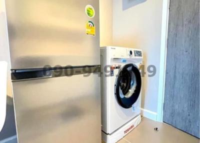 Modern utility room with a washing machine and refrigerator