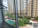 Panoramic view from apartment window overlooking swimming pool and adjacent building
