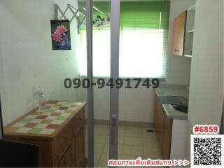 Compact kitchen space with tiled counters and natural light