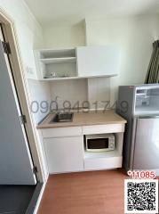 Compact kitchen area with white cabinets and modern appliances