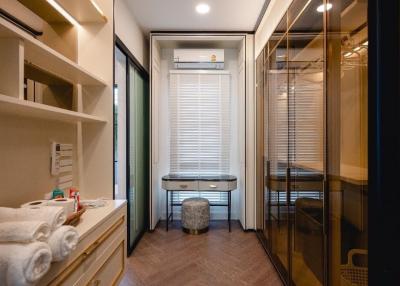 Modern compact bathroom with well-organized shelves, vanity sink, and enclosed shower area