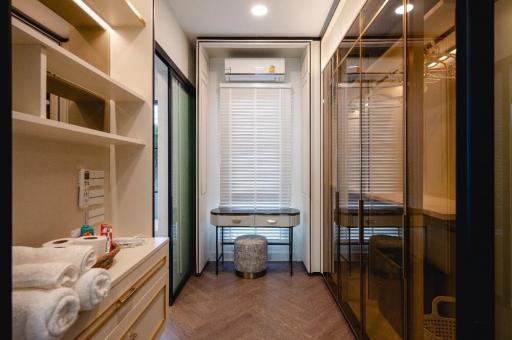 Modern compact bathroom with well-organized shelves, vanity sink, and enclosed shower area