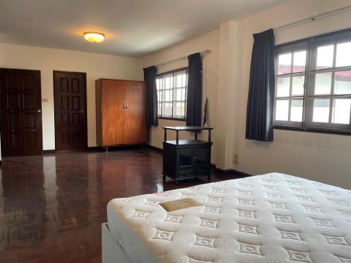 Spacious bedroom with natural lighting and wooden flooring