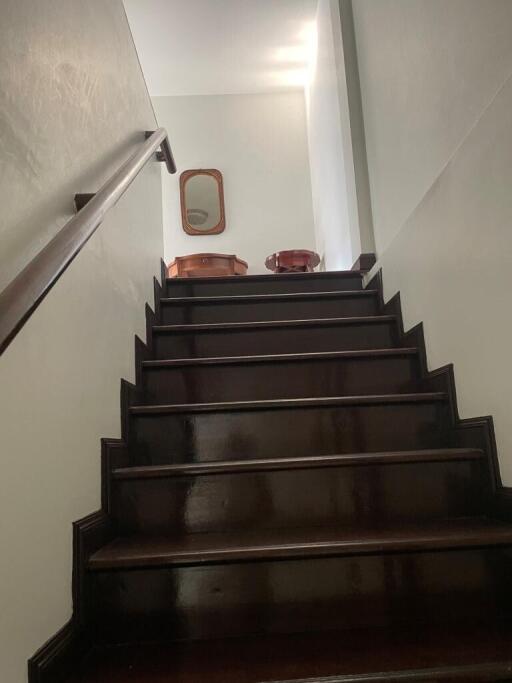 Polished wooden staircase with handrail leading to the upper floor