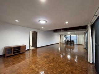 Spacious empty living room with parquet flooring and ample natural light