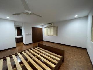 Spacious bedroom with wooden flooring and air conditioning