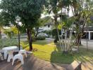 Lush green lawn with outdoor seating and surrounding residential buildings