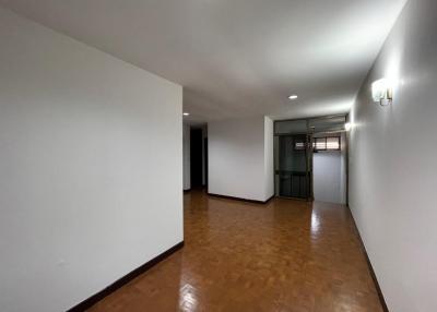 Spacious and empty living room with tiled flooring and ample wall space