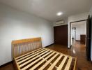 Empty bedroom with hardwood floor and white walls