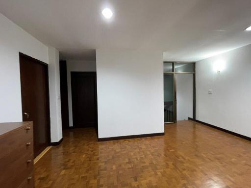 Spacious empty living room with hardwood flooring and white walls