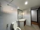 Spacious modern bathroom with tiled walls, large mirror, and clean design