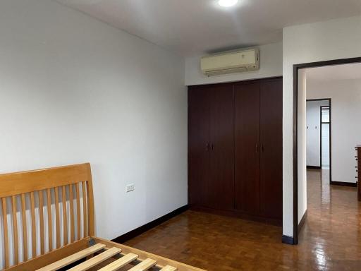 Spacious bedroom with wooden flooring and built-in wardrobe