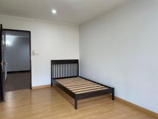 Minimalist styled bedroom with wooden bed frame and hardwood flooring