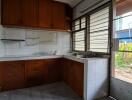 Spacious kitchen with wooden cabinets and large window