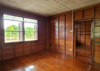 Spacious wooden bedroom with large window