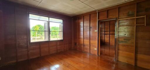 Spacious wooden bedroom with large window