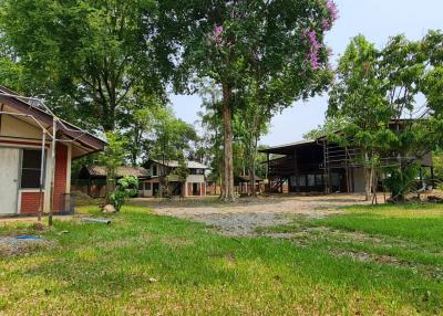 Rural property exterior with multiple buildings and green surroundings