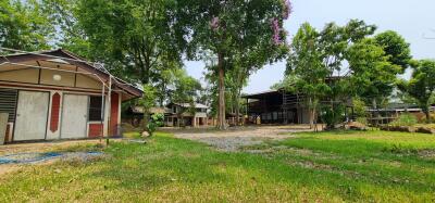 Rural property exterior with multiple buildings and green surroundings