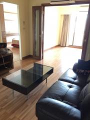 Spacious living room with hardwood floors, large sofa, and glass table