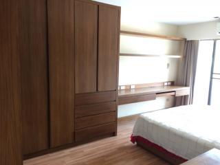 Spacious bedroom with large wooden wardrobe and comfortable bed