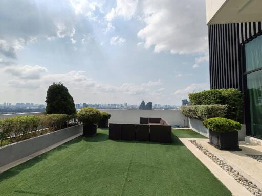 Spacious balcony with artificial turf and outdoor furniture overlooking the city skyline