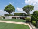 Spacious rooftop garden with seating and greenery under a clear blue sky