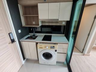 Compact modern kitchen with built-in appliances and laundry machine