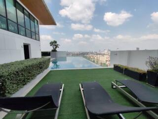 Rooftop infinity pool with sun loungers and a city skyline view