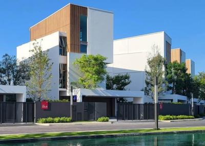 Modern residential apartment buildings with a reflection on a water feature in a clear sunny day