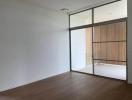 Modern bedroom with large sliding glass door and spacious built-in wardrobe