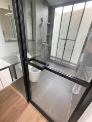 Modern bathroom with glass shower enclosure and grey tiles