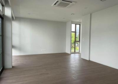 Spacious and empty living room with large windows and hardwood floors