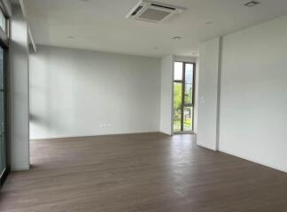 Spacious and empty living room with large windows and hardwood floors