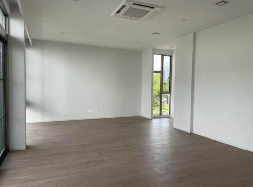 Spacious and empty living room with large windows and hardwood floors