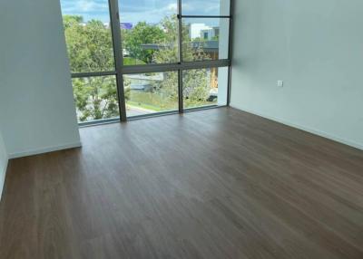 Empty interior of a modern building with large windows and hardwood flooring