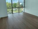 Empty interior of a modern building with large windows and hardwood flooring