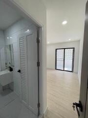 Modern corridor with a view into a bathroom and another room with french doors