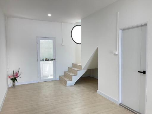 Bright and modern interior space with staircase and laminate flooring