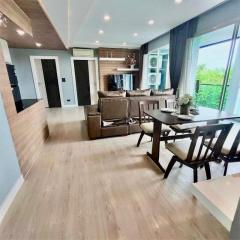 Modern living area with open dining space, leading to a balcony with a view