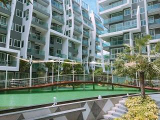 Modern apartment complex with landscaped artificial pond and pedestrian bridge